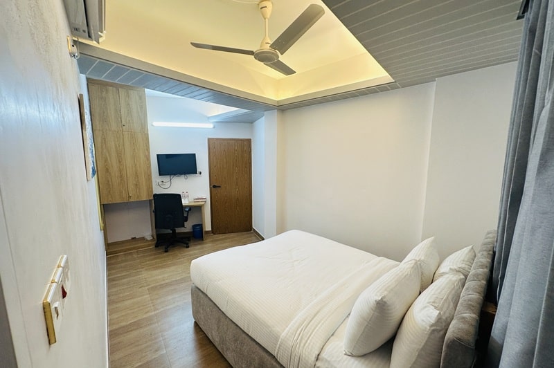 hotel room with grey curtain, brown floor