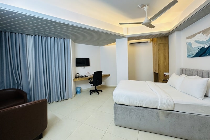 hotel room with white bed, white floor