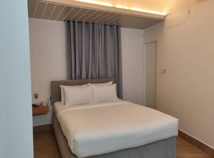 hotel room with grey curtain, brown floor