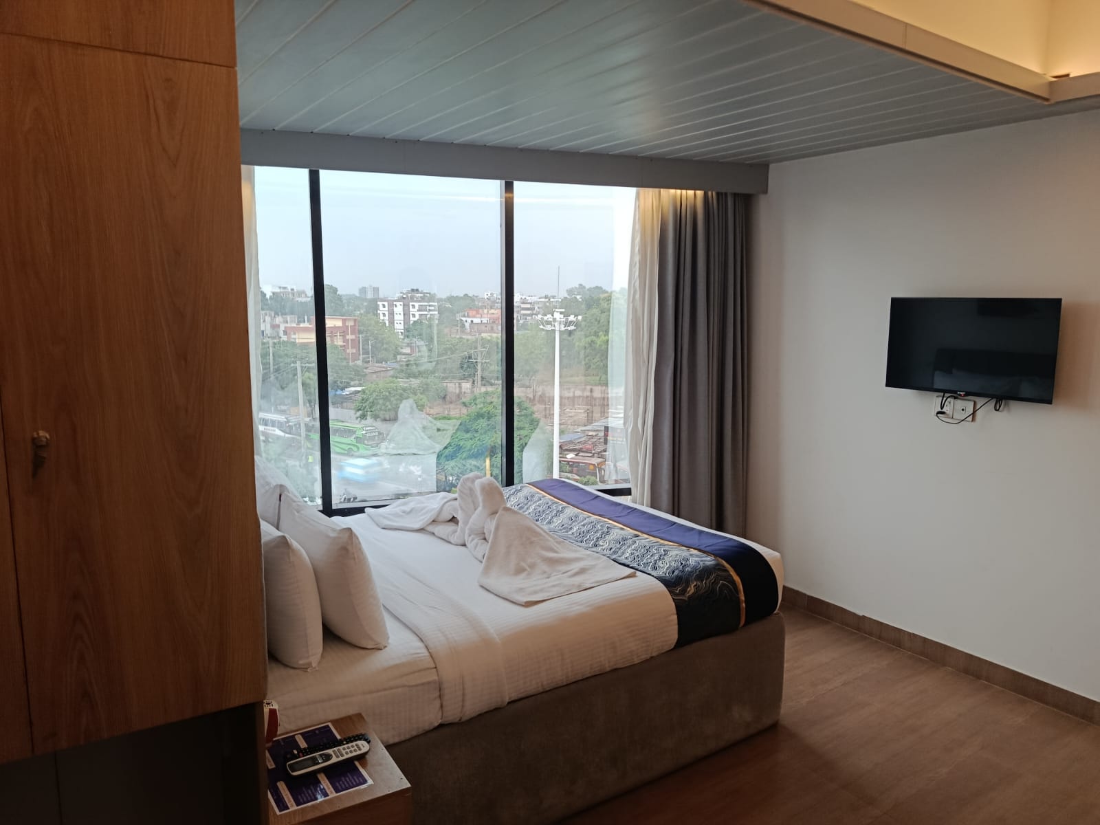 hotel room with grey curtain, brown floor