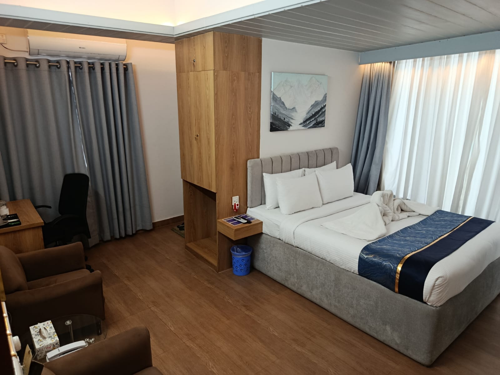 hotel room with grey curtain, brown floor